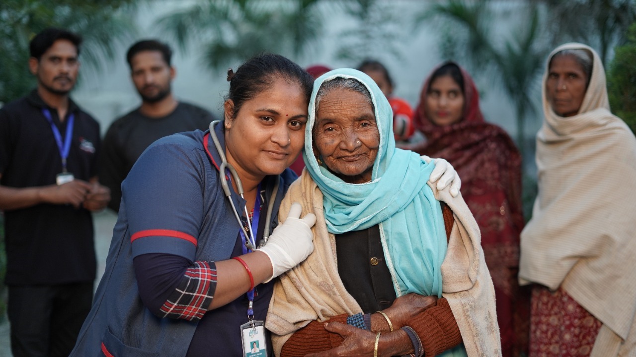 a LMC staff hugging an old lady